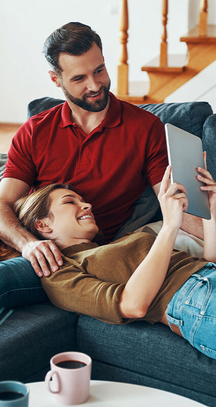 Die richtige Kreditberatung eröffnet neue finanzielle Spielräume. Ein Paar informiert sich am Tablet über die zahlreichen Kreditangebote von KREDIT.DE.
