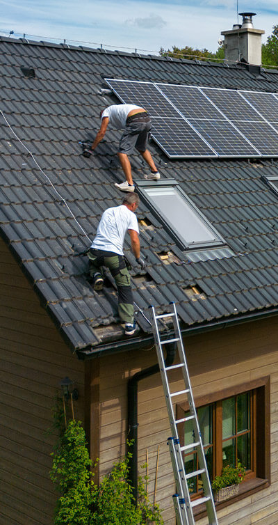 Zwei Männer bringen eine Solaranlage auf einem Dach an